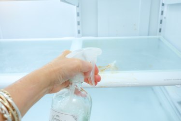 spraying cleaner in refrigerator