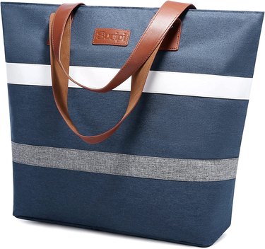 Large navy blue tote bag with brown faux leather handles, one white stripe, and one gray stripe. It's pictured against a white background.