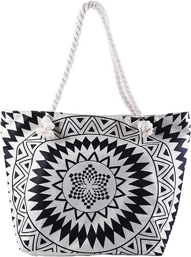 Oversized beach bag with a black and white geometric print and knotted rope handles. It's pictured against a white background.