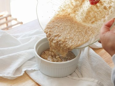 Pouring scrub into smaller bowl.