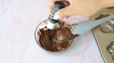 Adding black food coloring to melted milk chocolate