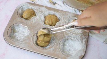 Scooping madeleine batter into pan