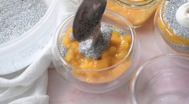 Layering chia seed and pureed mango in a cup.