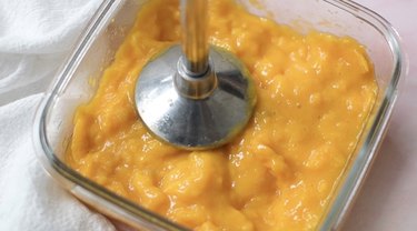 Pureeing mangoes with immersion blender.