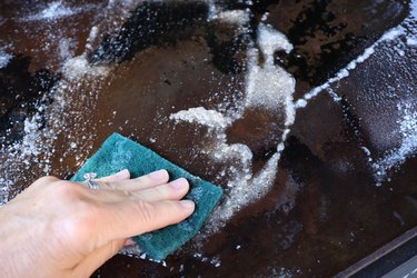 scrubbing flat top grill with kosher salt and oil