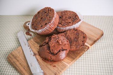 Two chocolate Costco muffins with the muffin tops cut off