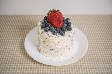 Lemon poppy seed cake topped with blueberries and a strawberry