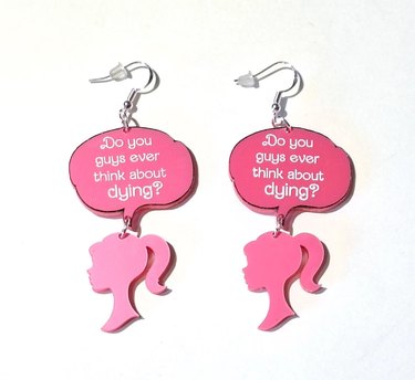 Pair of earrings with Barbie head and "do you guys ever think about dying?" thought bubble