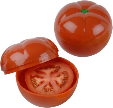 Two tomato savers, one with the lid halfway off revealing a sliced tomato
