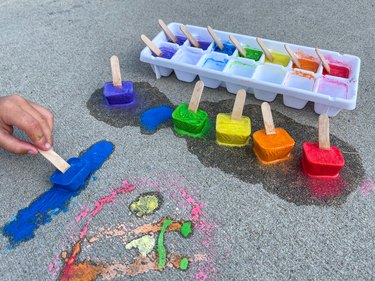 drawing with blue ice chalk on sidewalk