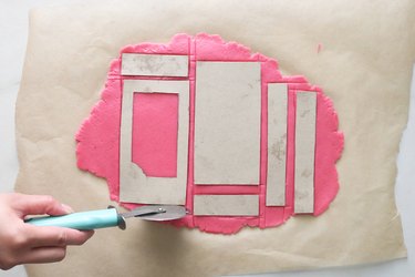Cutting out pink sugar cookie dough for Barbie box cookies