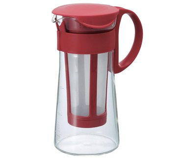 A 600 ml Hario cold brew coffee pot in red against a white background. The filtration happens in the pourable glass pot, which is tall and slender.