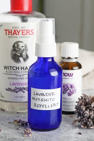 Bottle of lavender mosquito repellent next to witch hazel water and lavender oil