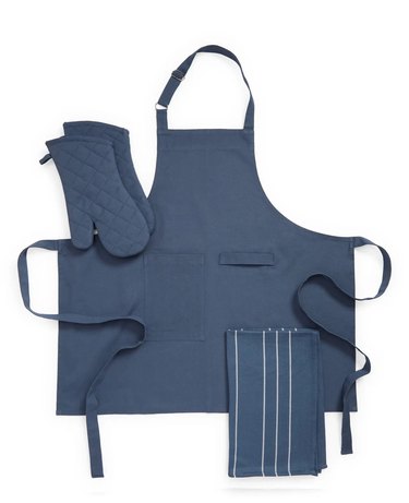 Nordstrom Kitchen Starter Kit: Navy blue apron, tea towel (with thin white stripes), and quilted oven mitts. All of them are matching and pictrued against a white background.