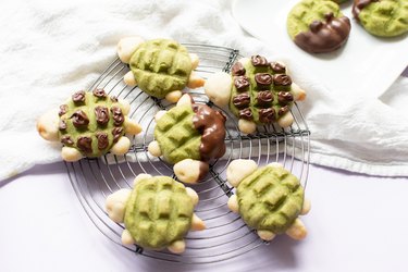 Baked matcha and chocolate turtle cookies on a wire rack.