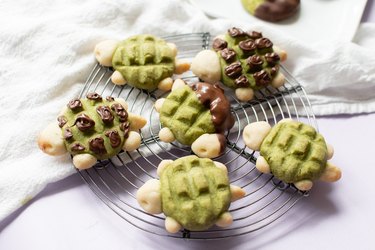 Matcha and chocolate turtle cookies on a circle wire rack.