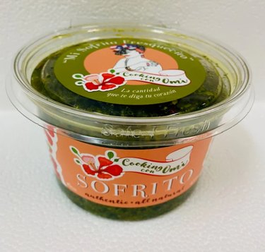 A plastic container filled with Cooking con Omi's green Sofrito, perfect for adding to kebabs.