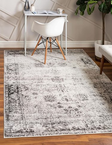 Vintage rug underneath a small desk and desk chair