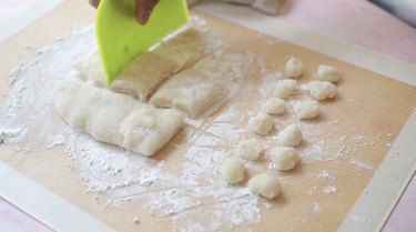 Dividing mochi with bench scraper