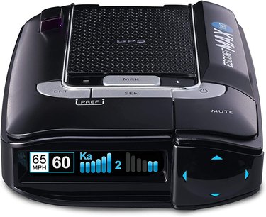 Small black radar detector against a white background. It shows you the speed limit as well as your current speed.