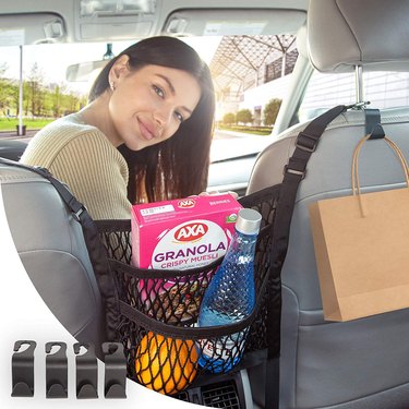 Woman sitting in front seat next to hanging snack holder full of snacks.