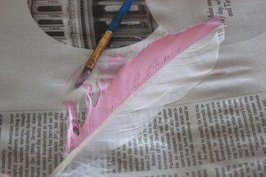 half of a feather painted light pink