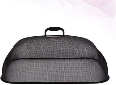 A large, rectangular stainless steel mesh food cover against a white and pink background.