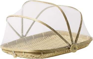 A bamboo and mesh food protector with a picnic basket-like design.