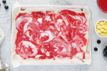 Yogurt with raspberry swirls on a baking sheet