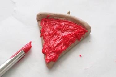 Adding red polymer clay to charms for pizza slice BFF necklaces