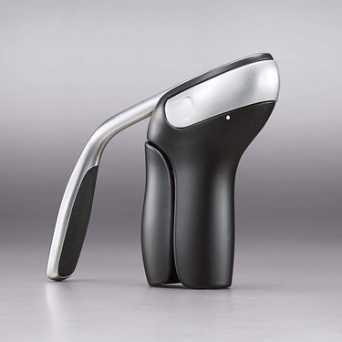 OXO vertical lever corkscrew in black and stainless, shown against a two-tone grey background