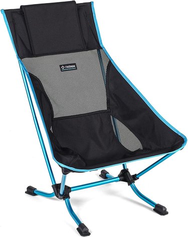Helinox Beach Chair in against a white background. The chair is black with light blue trim and matching metal legs.