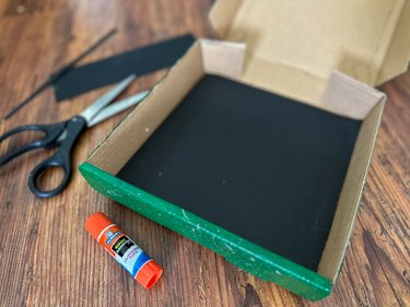 Add black paper to bottom of box