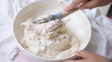 Mixing focaccia dough with a rubber spatula