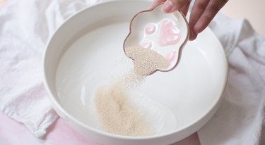Pouring yeast into bowl of water