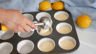 adding cupcake batter into cupcake pan