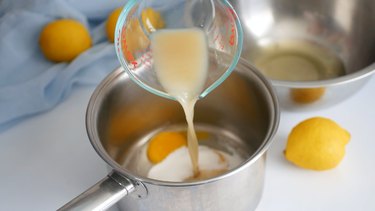 adding lemon juice to lemon curd pot