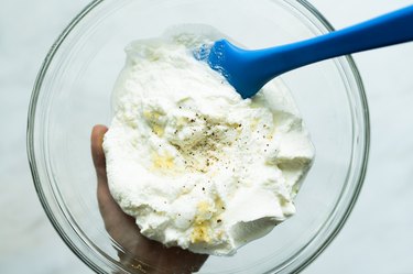 preparing ricotta mixture in a bowl with a spatula.