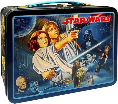 Star Wars-themed tin lunch box with all the major characters on the front, most prominently Luke and Leia.