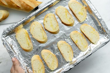 crostinis before baking on a baking sheet.