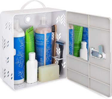 White shower caddy with shower items inside, a mirror and a lock