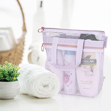 Lilac mesh shower tote with rose gold zippers and geometric patterned matching ribbon on the top and handles.