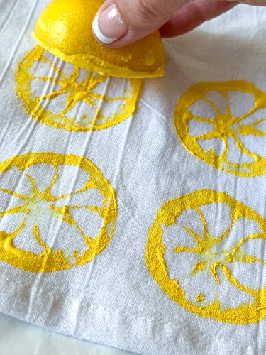 press lemon onto tea towel