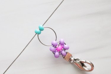 Turquoise beads on wire with a purple and pink beaded daisy