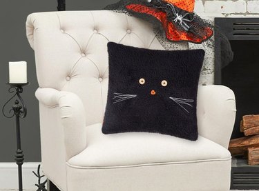 Black Cat Halloween Throw Pillow from Target. It's black sherpa material with button eyes and a nose and 3D whiskers.