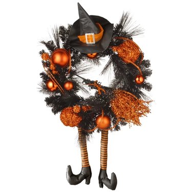 Black and orange wreath with a witch's hat and legs, as well as sparkling pumpkins and baubles.