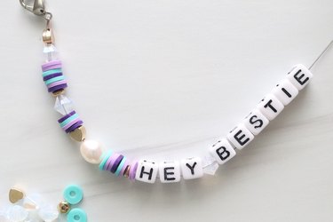 Letter beads spelling "Hey Bestie" on a wire