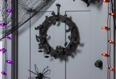 Black Halloween wreath resembling grapevine with felt bats all around it.