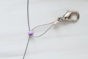 A purple seed bead on wire for a daisy chain bracelet