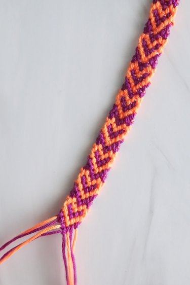 Purple and orange heart friendship bracelet made of embroidery thread